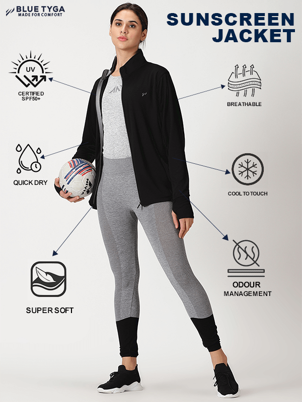 Active woman holding a soccer ball while dressed in a Blue Tyga sunscreen jacket, featuring UV protection certified SPF50+, breathability, quick-dry fabric, super soft feel, cool to touch feature, and odour management technology